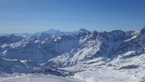 Scenic view of snowcapped mountains against clear blue sky