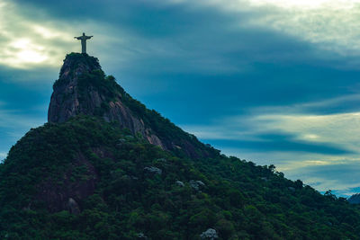 Cross on mountain against sky