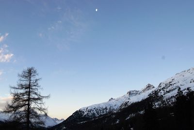 Low angle view of snowcapped mountains against sky