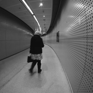 Rear view of woman walking in subway