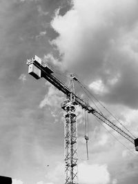 Low angle view of crane at construction site against sky