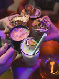 Friends group cheering cocktails at the bar. young people have funny drinking party in happy hour. 