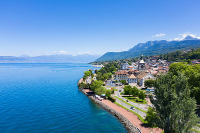 Scenic view of sea by buildings against blue sky