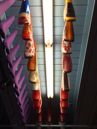 Low angle view of bicycle seats hanging from illuminated ceiling
