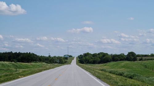 Road amidst trees against sky