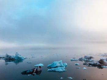 Scenic view of ice floating on sea against sky