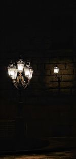 Low angle view of illuminated lamp at night