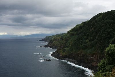 Scenic view of sea and mountains against sky
