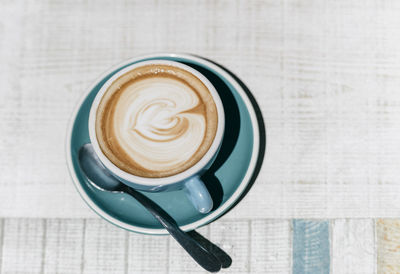 A stylish cup of coffee with latte art on white background table. 