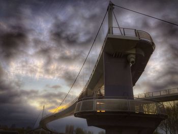 Low angle view of bridge against cloudy sky