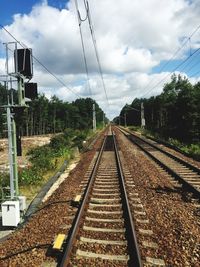 Railroad tracks against cloudy sky