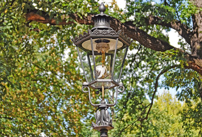 Low angle view of gas lantern against trees