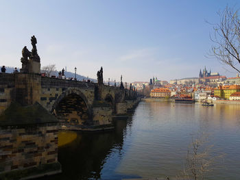 Bridge over river against buildings in city