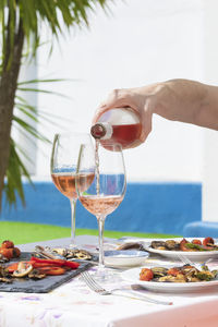 Hand of woman pouring delicious rose wine