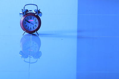 Close-up of clock on table against wall