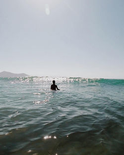 Man in sea against clear sky