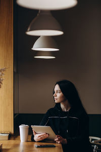 Portrait of young woman sitting at home