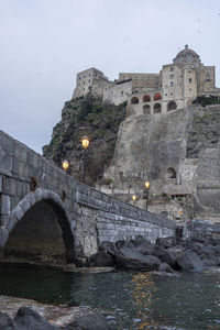 Arch bridge over river against buildings