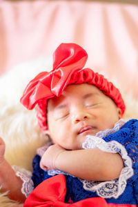 Portrait of cute baby girl lying on bed