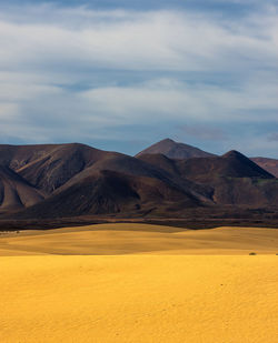 Scenic view of arid landscape against sky