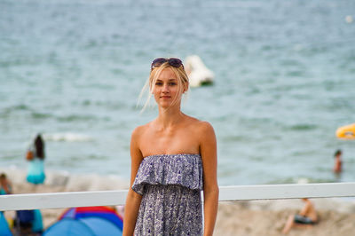 Portrait of young woman standing at beach