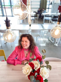 Portrait of smiling young woman sitting at home