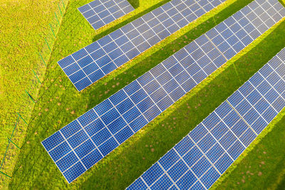 High angle view of solar panels on grassy field