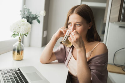 Young woman using laptop at home