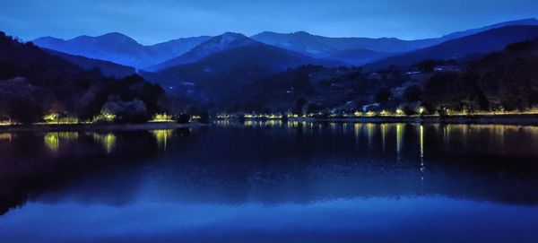 Scenic view of lake and mountains against clear blue sky