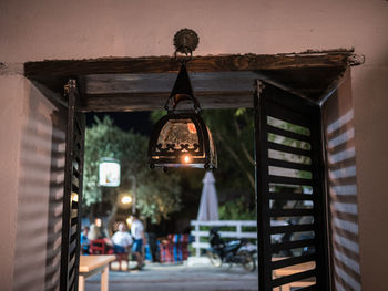 Illuminated lanterns hanging by building