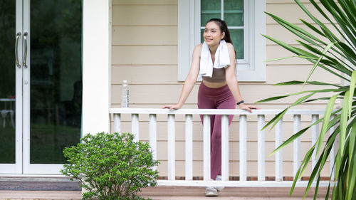 Portrait of woman standing against built structure