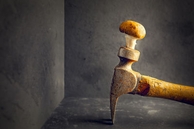 Close-up of rusty metal on floor against wall