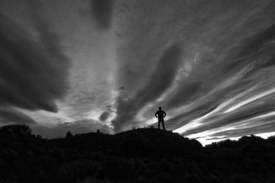 Low angle view of silhouette man standing on land against sky