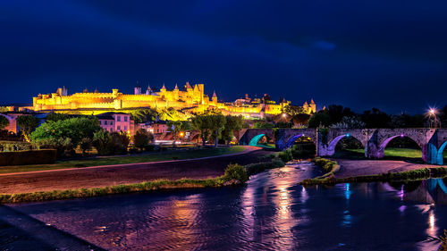 Arch bridge over river at night