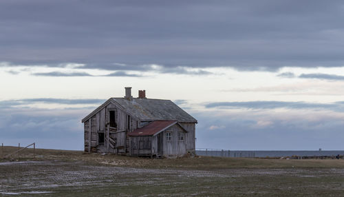 Abandoned building on field against sky