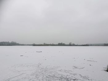 Scenic view of lake against sky during winter