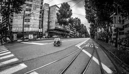 Vehicles on road by buildings in city