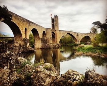 Arch bridge over water against sky