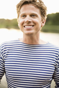 Mid adult man looking away while smiling outdoors