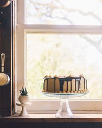 Close-up of cake on window sill at home