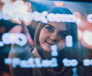 Futuristic. young woman behind the transparent screen with codes.