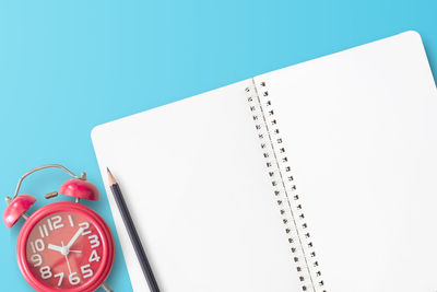 High angle view of clock on table against blue background