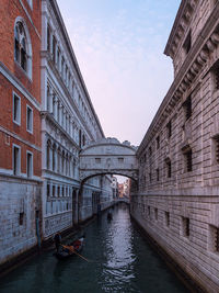 Canal amidst buildings against sky