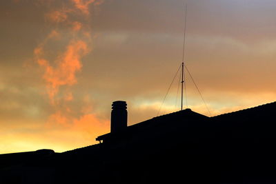 Low angle view of silhouette tower against sky during sunset