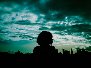 Silhouette people against cloudy sky