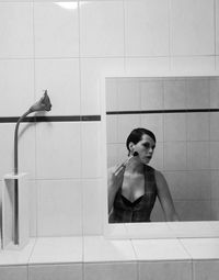 Young woman sitting in bathroom