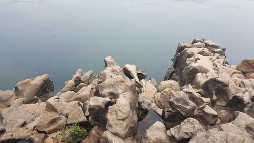 Rocks by sea against sky