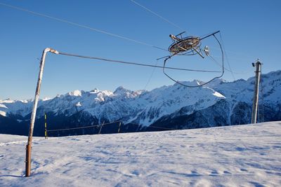 Overhead cable car on snowcapped mountains against clear sky