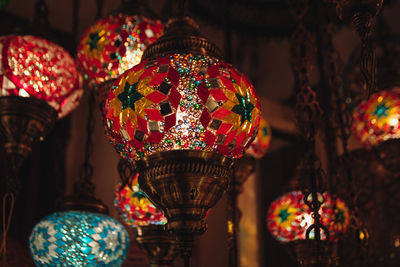 Illuminated lanterns hanging in market for sale