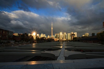 View of city lit up against cloudy sky